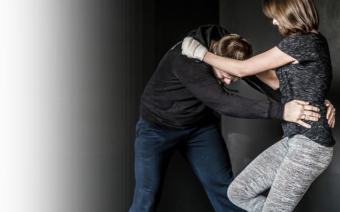 A woman practicing a Krav Maga self-defense technique with a partner